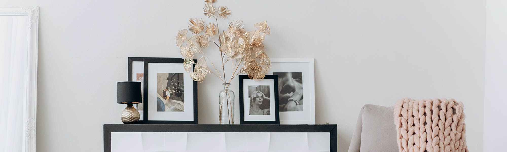 Decorations and photos in photo frames on a stylish shelf in the living room