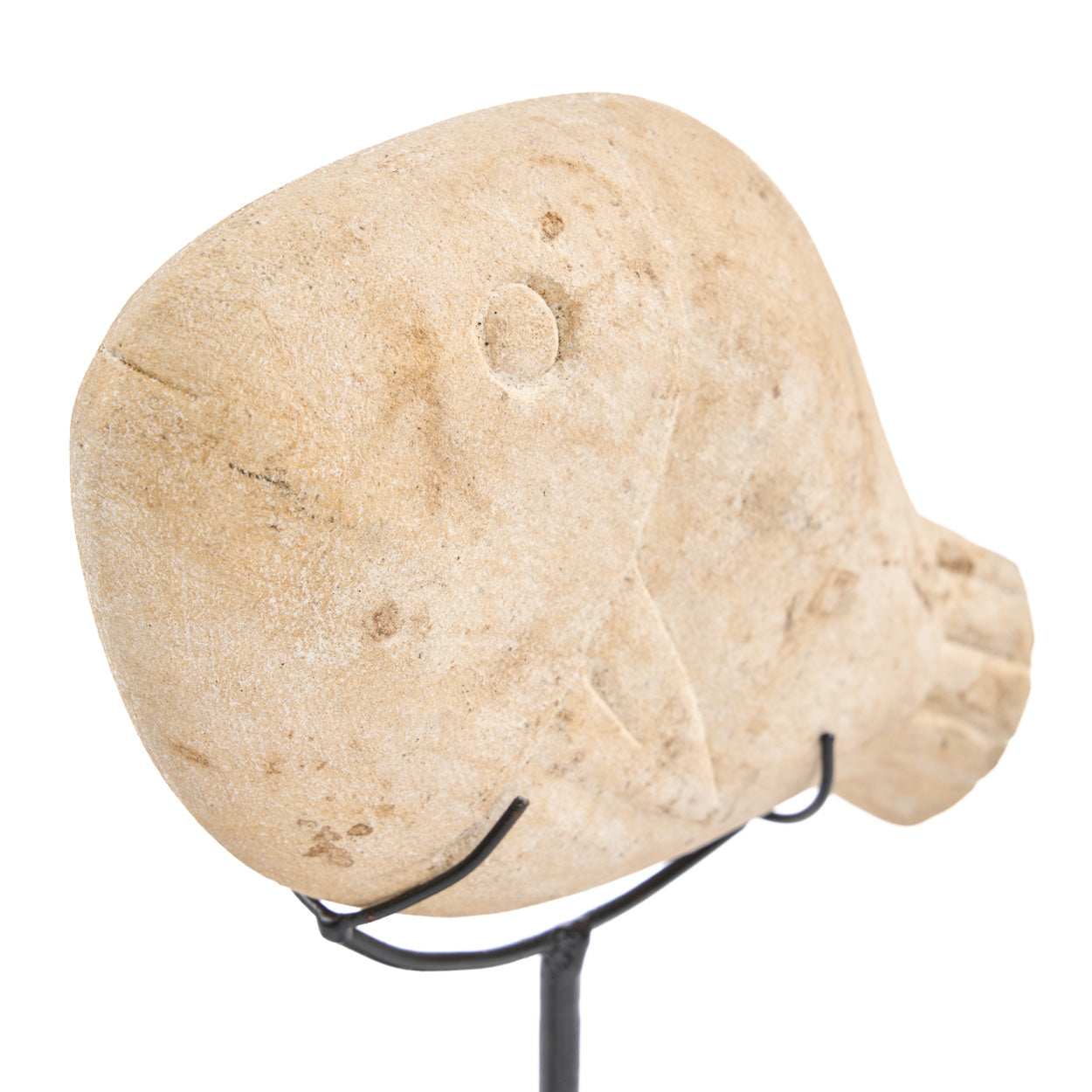 Decorative stone fish on a stand against a white background