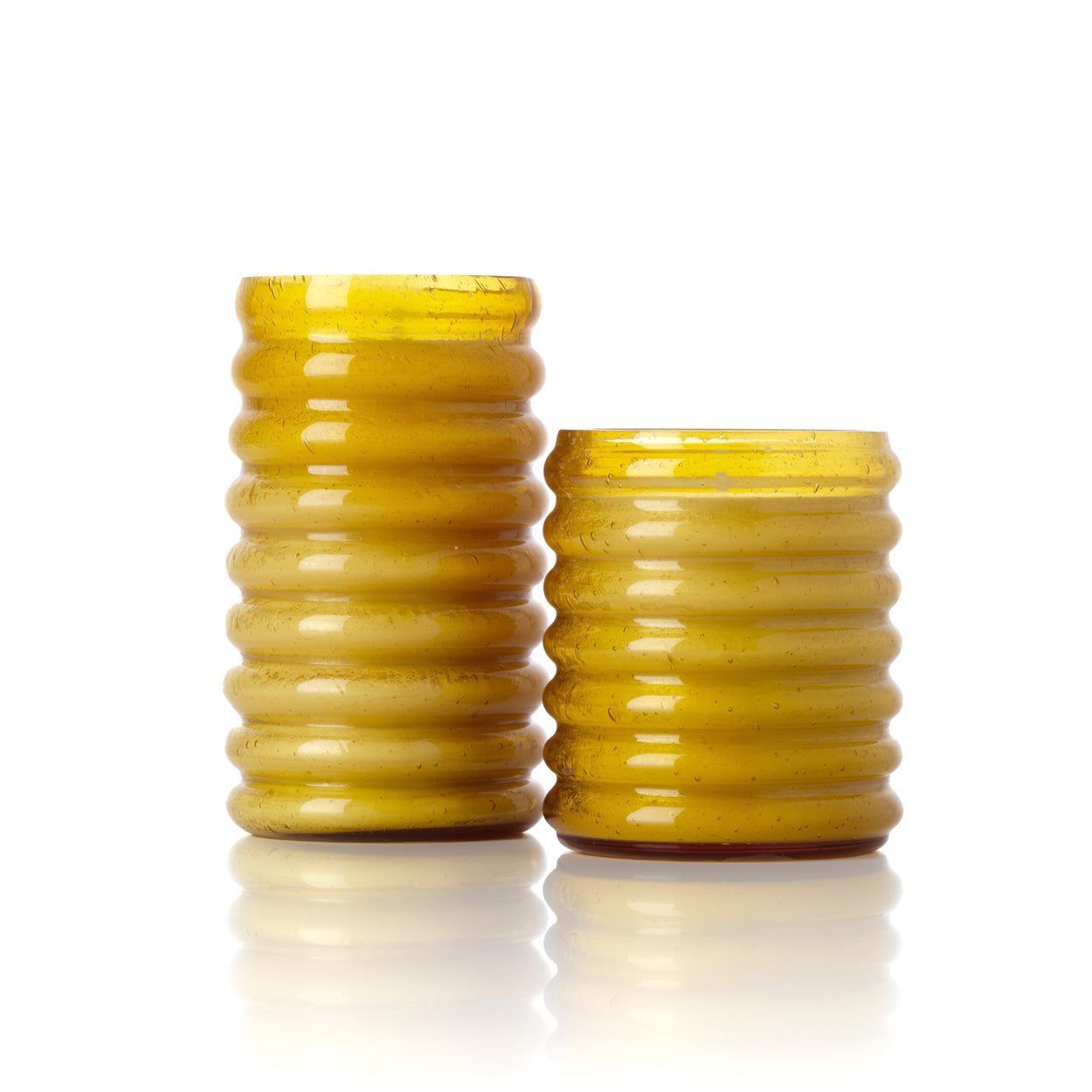 Two yellow textured glass candle holders on a white background