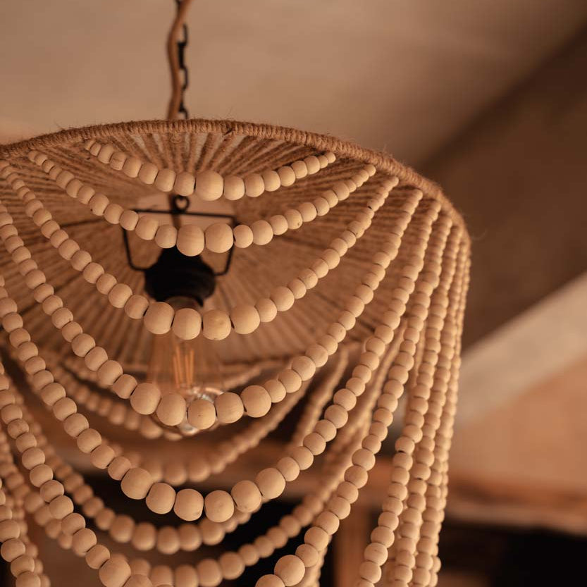Close-up of a beaded chandelier with a warm, beige background