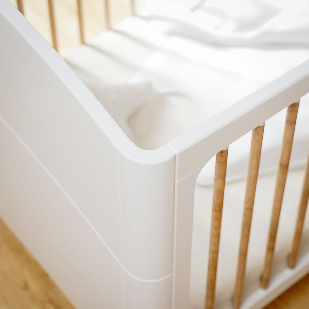 Close-up of a NEREE LIT Bed 70X140 - Neige with wooden bars on a light wooden floor.