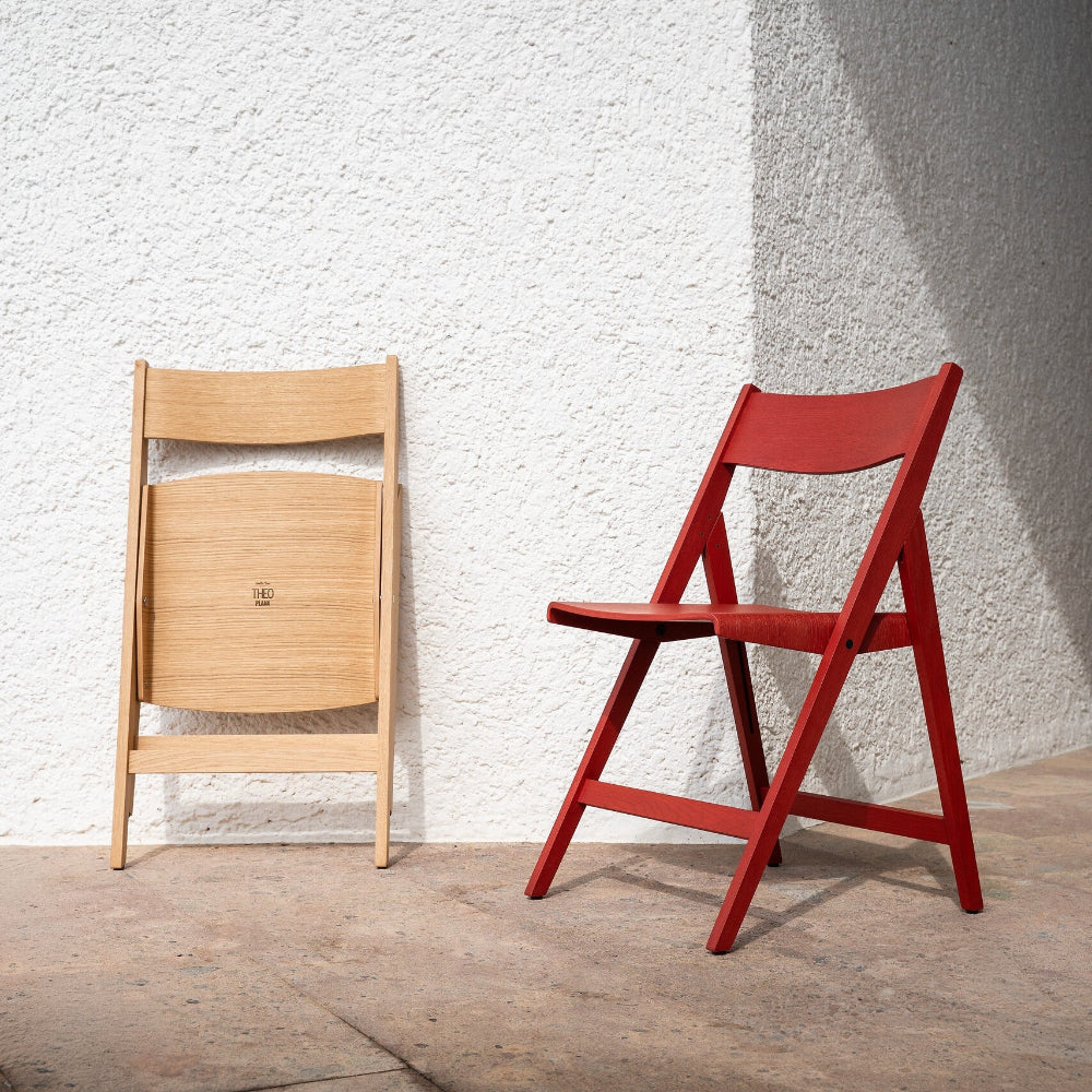 Oak natural and oak red THEO chairs against a textured white wall.